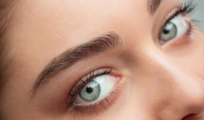 blicke_WEB_800.jpg Naheaufnahme eines Gesichts mit betonten Augenbrauen und strahlend blauen Augen.