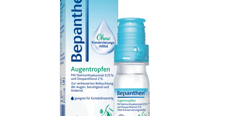 Bepanthen Augentropfen in einer transparenten Flasche mit blauer Verschlusskappe und einer Verpackung in Blau und Weiß.