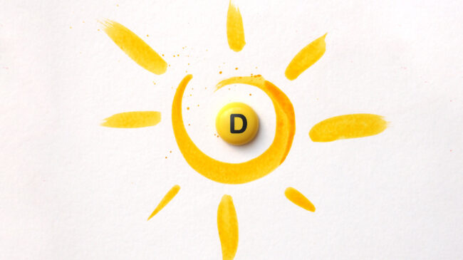 vitamind-sonne.jpg Gelbe Malerei eines Sonnenmotivs mit einer runden, gelben Pille mit dem Buchstaben D in der Mitte.