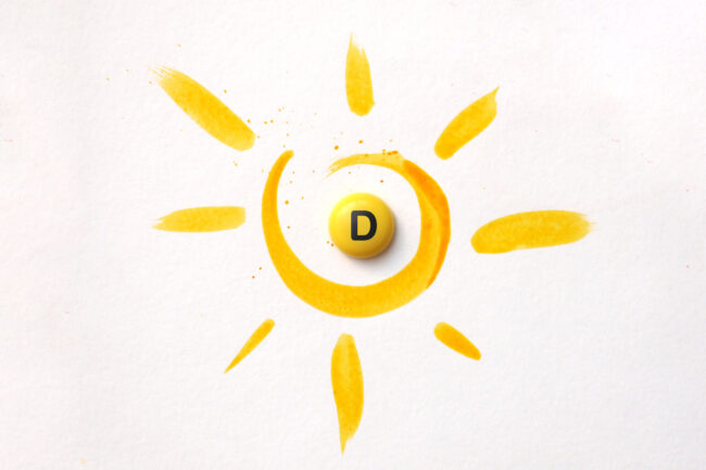 Gelbe Malerei eines Sonnenmotivs mit einer runden, gelben Pille mit dem Buchstaben D in der Mitte.