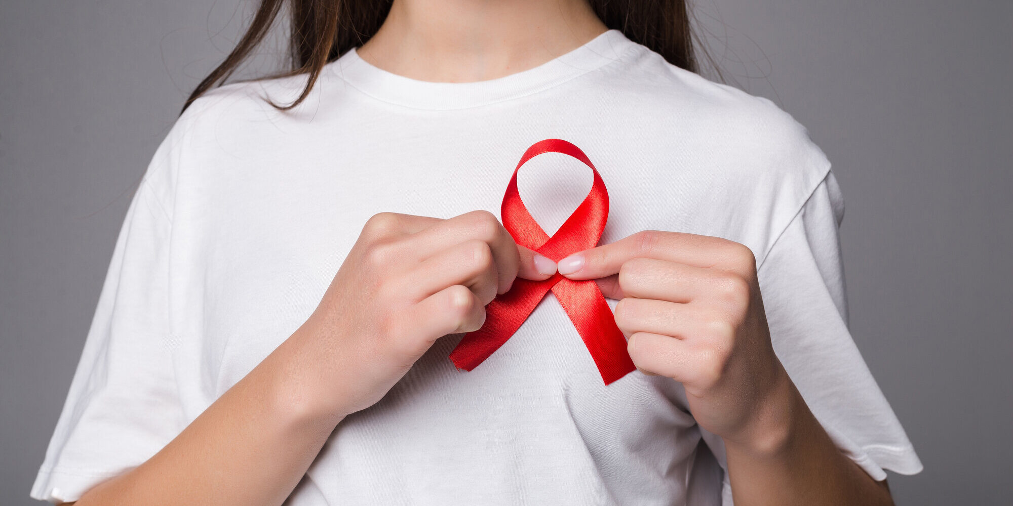 woman-holding-breast-with-pink-ribbon-white-wall-concept-photo-support-breast-cancer-cause-ps-you-can-change-pink-ribbon-into-red-aids-support-cause.jpg
